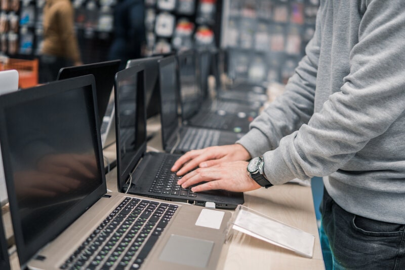 Someone typing on a laptop in a computer store